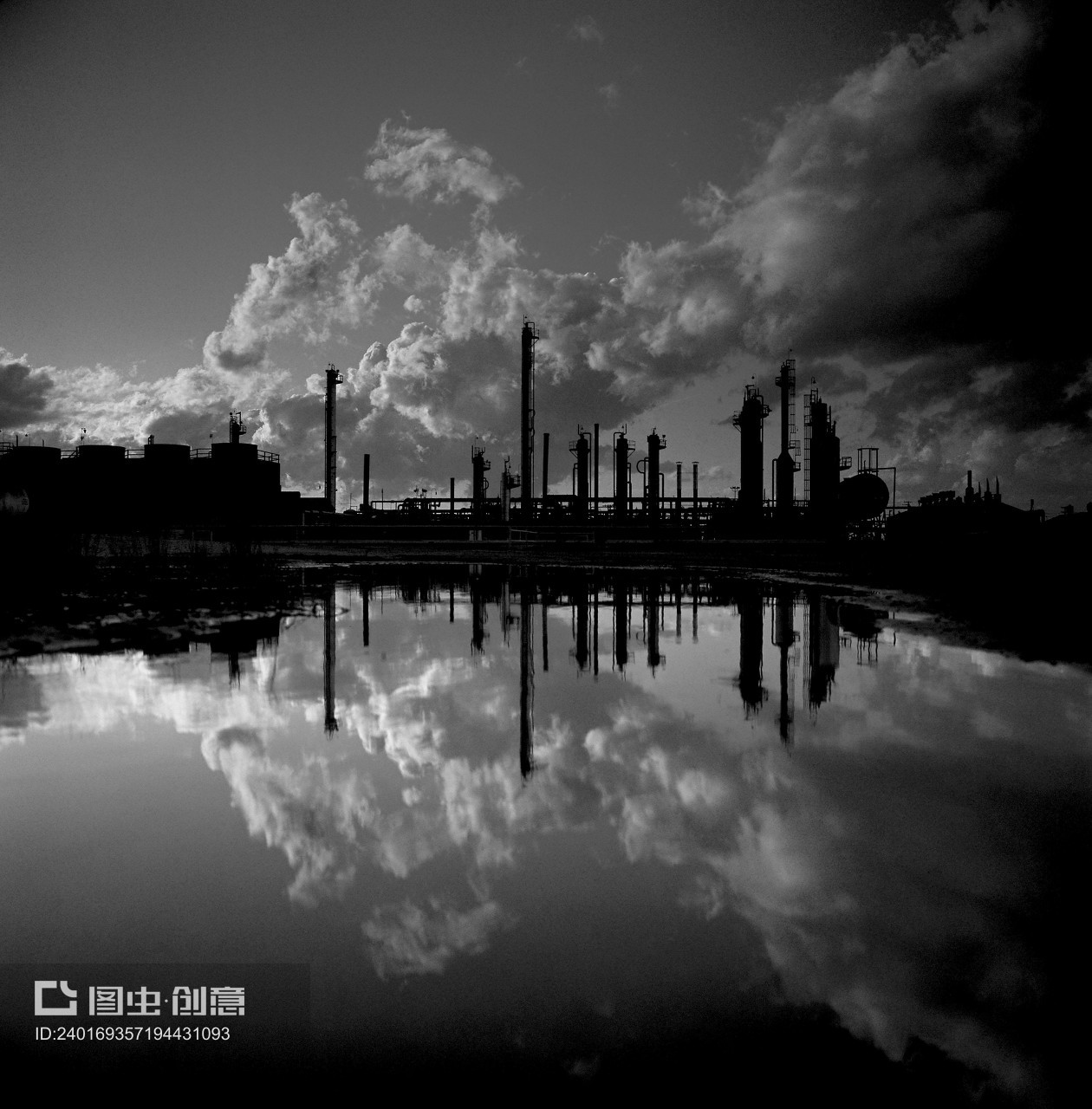 Refinery stacks are reflected in water